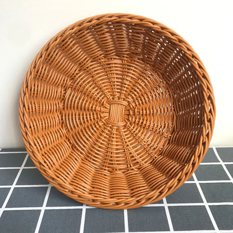 A round, brown handwoven wicker serving basket with a tight woven pattern.