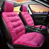 Pink plush winter car seat cover with backrest installed in a dark car interior.