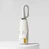 A white compact folding umbrella with a textured handle is shown against a light gray background.
