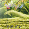 A set of lifelike dragonfly garden clips with insect repellent designs hanging from thin wires in a grassy outdoor setting.