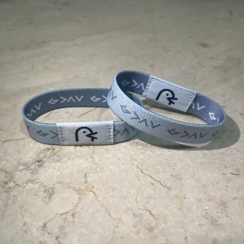 A silver-gray NFC Bible verse bracelet is displayed on a light surface.