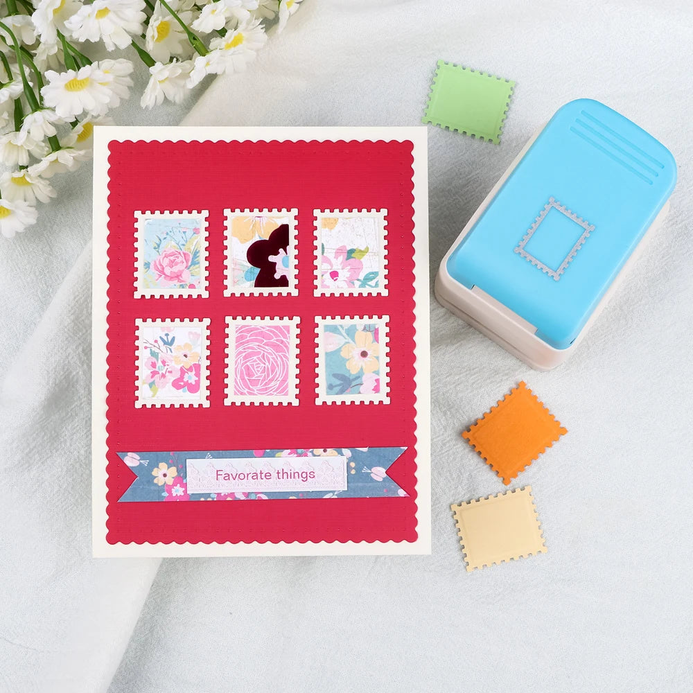 A blue embossing punch and several paper stamps are displayed on a white cloth.