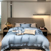 Helles blaues Luxus-Bambus-Bettwäsche-Set auf einem Bett mit neutralem Kopfteil und modernem Licht.