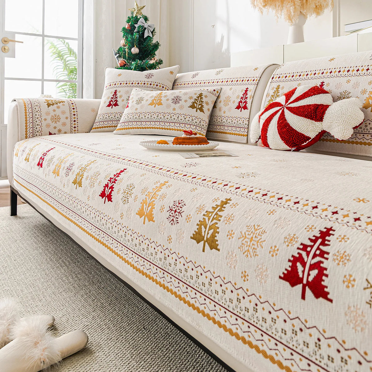 A beige sofa covered with Christmas tree chenille fabric featuring gold and red snowflake patterns.
