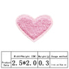 A pink heart shaped embroidered iron-on patch with a crosshatch texture.