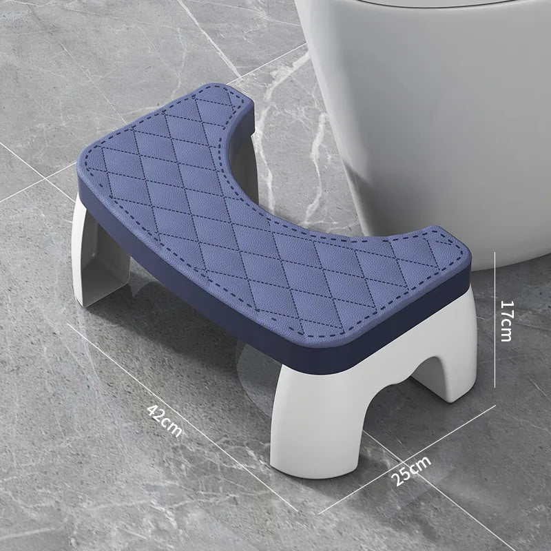 A purple ergonomic non-slip toilet squat stool with a diamond pattern is shown next to a white toilet bowl.