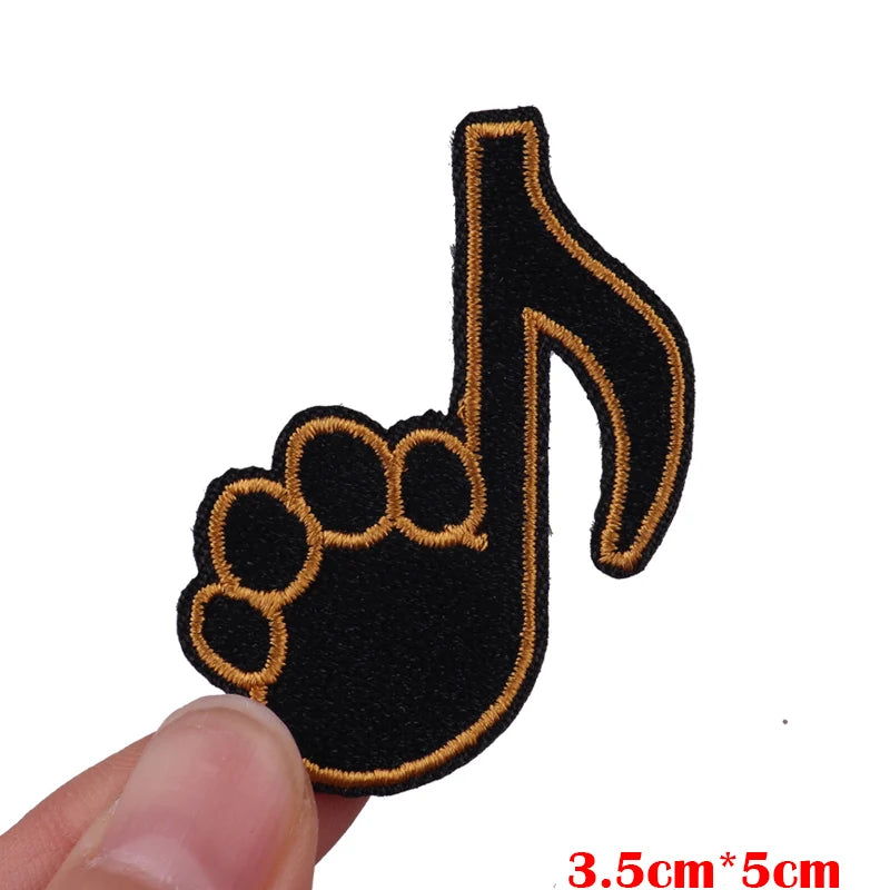 Black and gold embroidered iron-on patch shaped like a hand with a musical note.