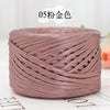 A spool of metallic rose gold flat ribbon yarn for crochet and knitting
