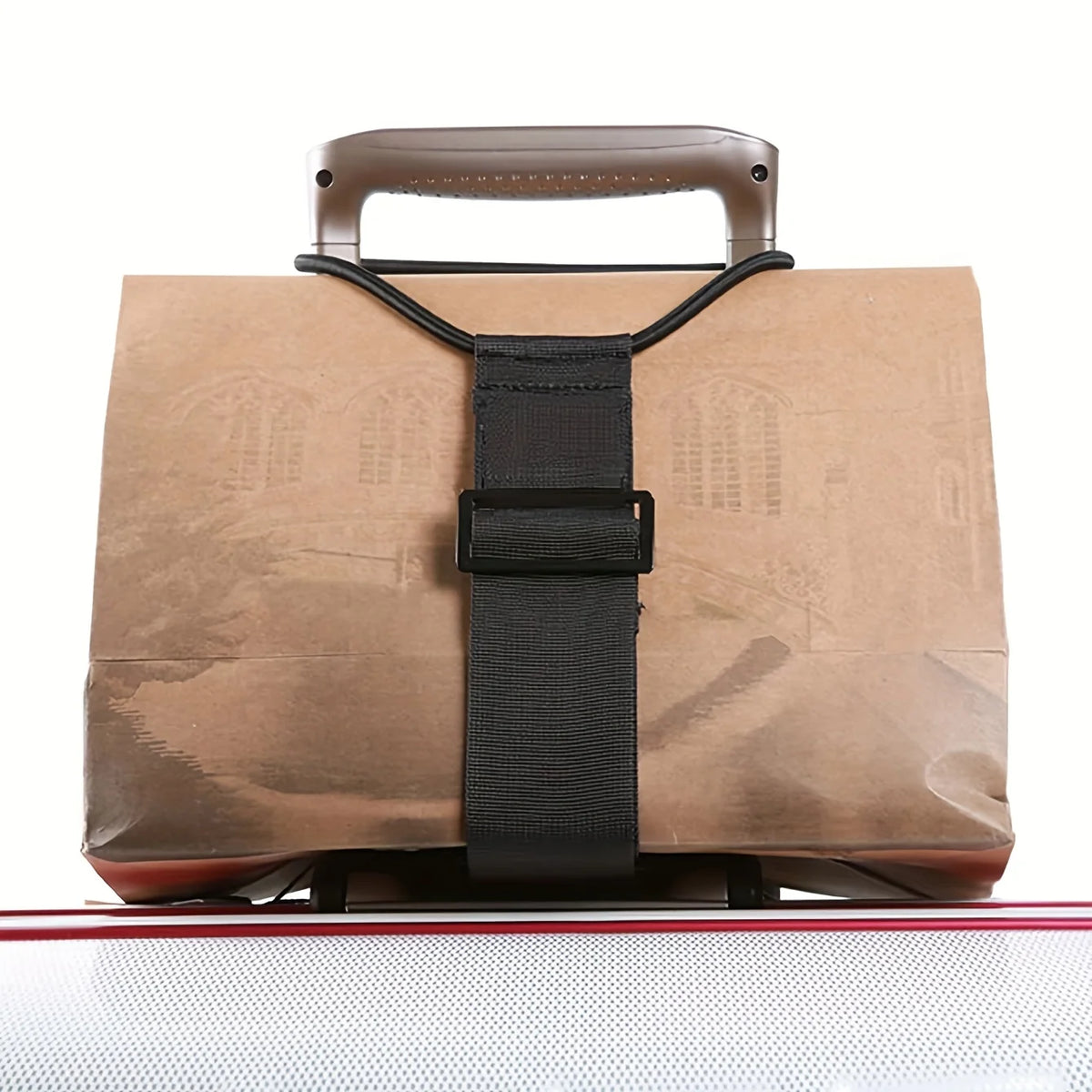 A brown reusable elastic luggage strap with a leather handle and black strap is shown on a reflective surface.