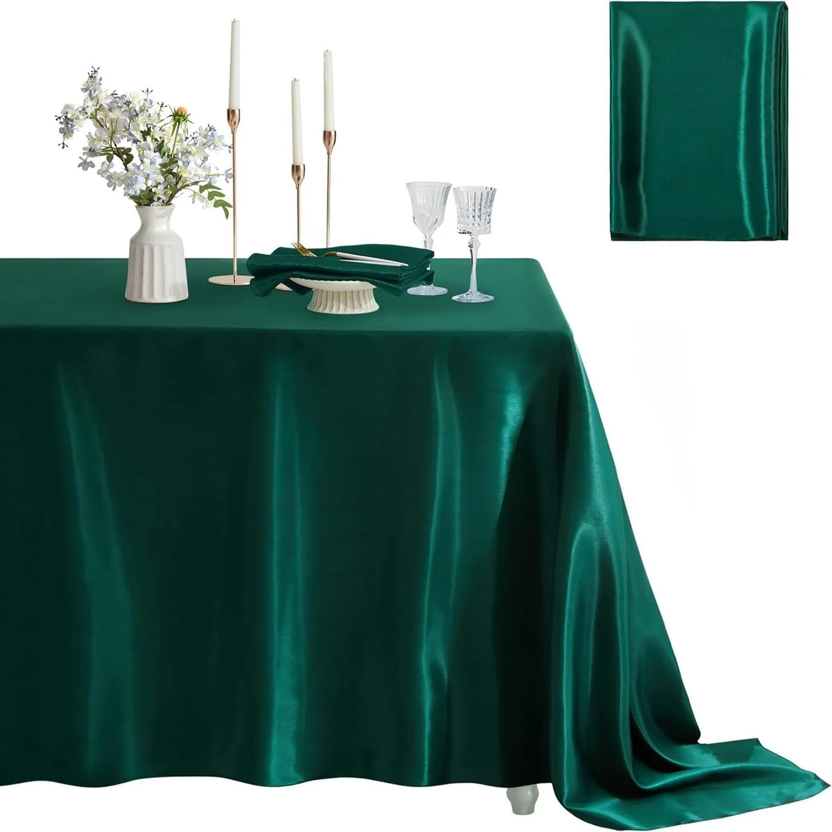 Emerald green satin tablecloth set with a floral centerpiece and tall candles.