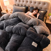 A person relaxing under a cozy double-sided velvet warm quilt blanket on a bed.