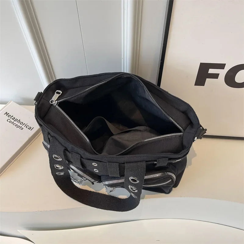A black nylon shoulder bag with silver chain accents is displayed on a white surface.