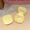 A yellow compact contact lens travel case with an open lid displaying clear lenses and storage compartments.