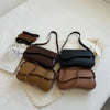 A collection of vintage brown and black leather crossbody bags displayed on a white surface.