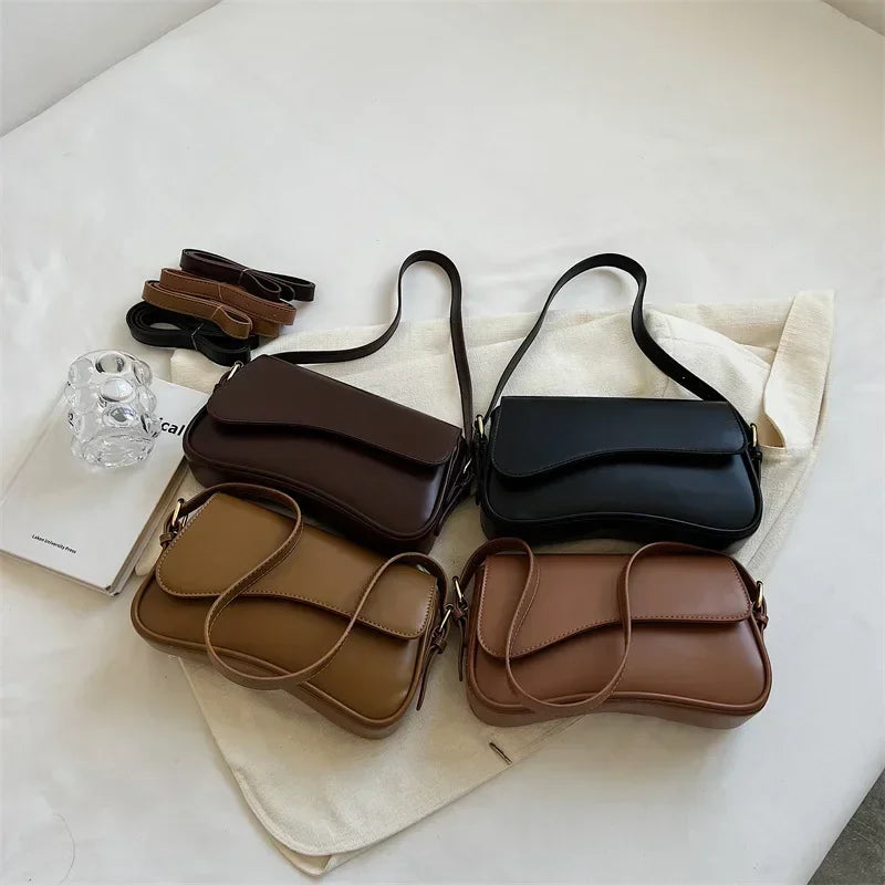 A collection of vintage brown and black leather crossbody bags displayed on a white surface.