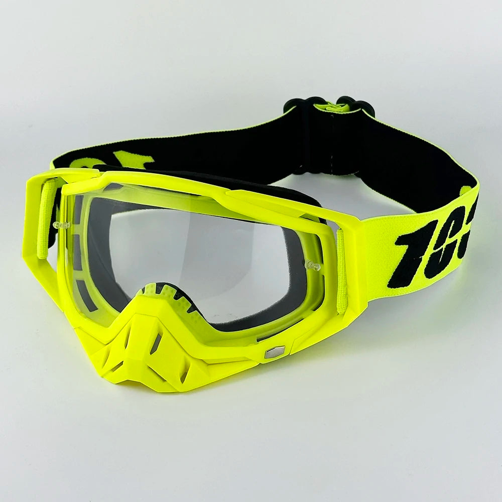 A pair of bright yellow motorcycle goggles with black straps and a clear lens.