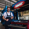 A man stands in front of a red Peterbilt truck neon sign with USB power.