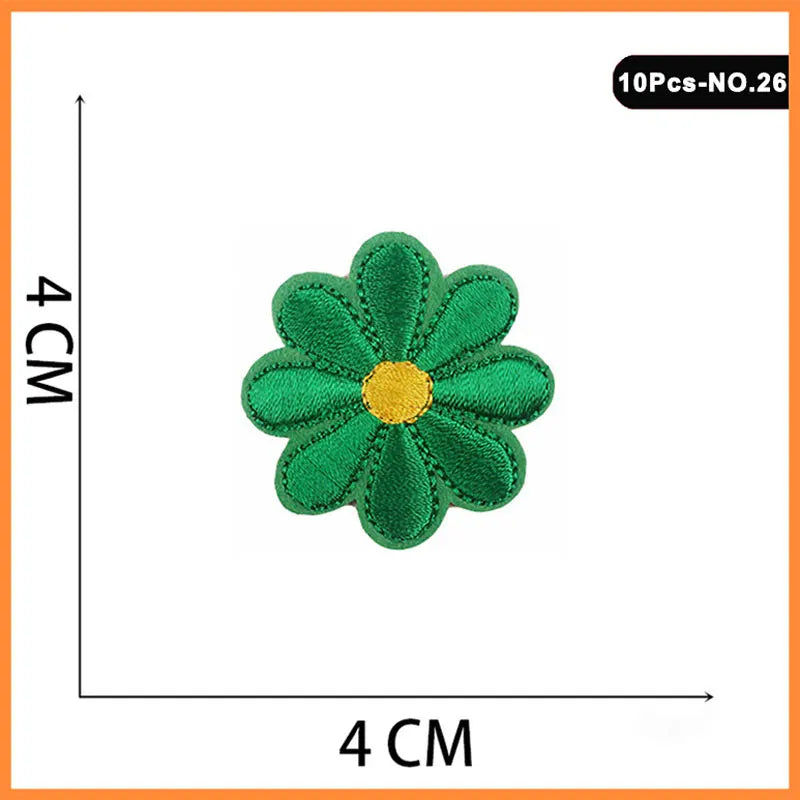A green embroidered patch shaped like a flower with a yellow center, measuring 4 cm by 4 cm.