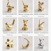 A collection of handcrafted ceramic elephant and rabbit jewelry holders and desk ornaments in gold color.