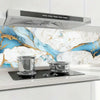 A stainless steel range hood is mounted above a kitchen counter with marble-patterned backsplash.