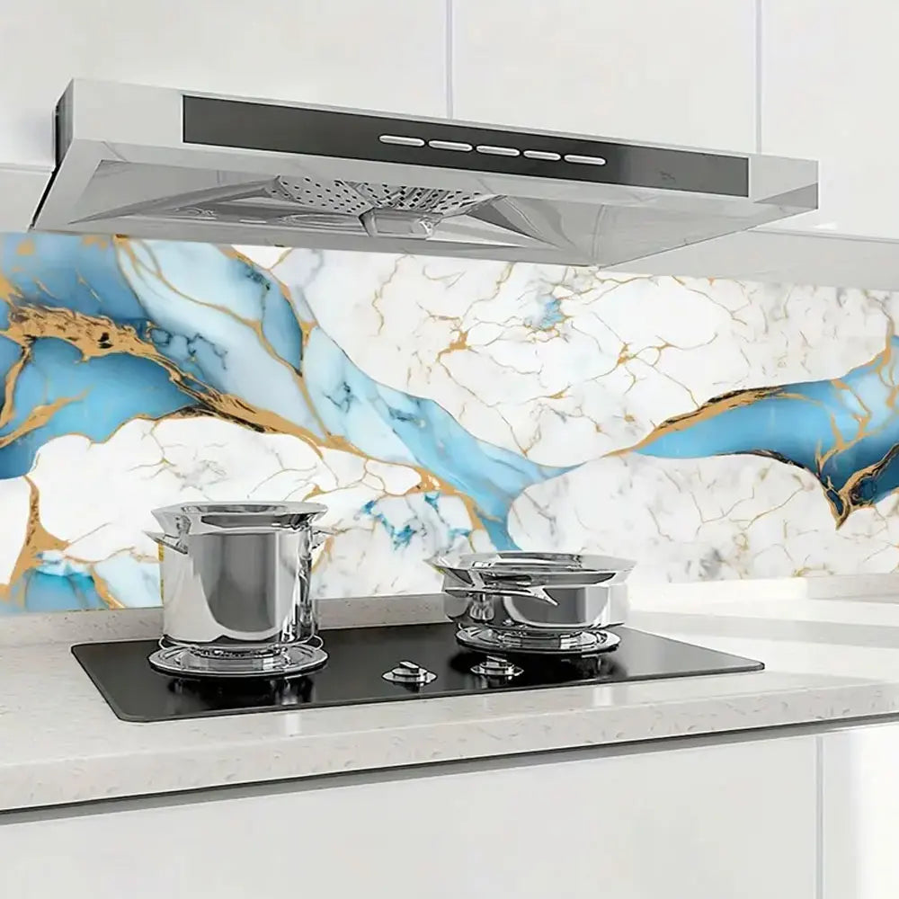 A stainless steel range hood is mounted above a kitchen counter with marble-patterned backsplash.