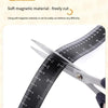 A pair of silver scissors cutting through a black magnetic flexible measuring ruler.
