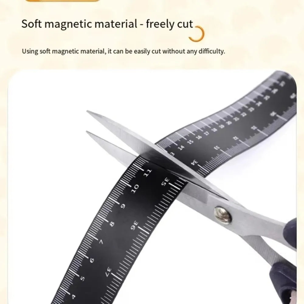 A pair of silver scissors cutting through a black magnetic flexible measuring ruler.
