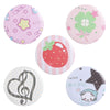 A set of colorful tinplate pins featuring designs like a pink floral pattern, a green clover, a strawberry, a treble clef, an