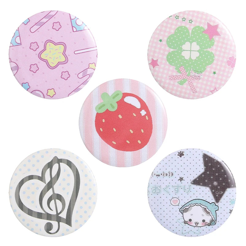 A set of colorful tinplate pins featuring designs like a pink floral pattern, a green clover, a strawberry, a treble clef, an