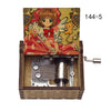 A music box featuring a Cardcaptor Sakura character, with an open wooden case and a hand crank mechanism.