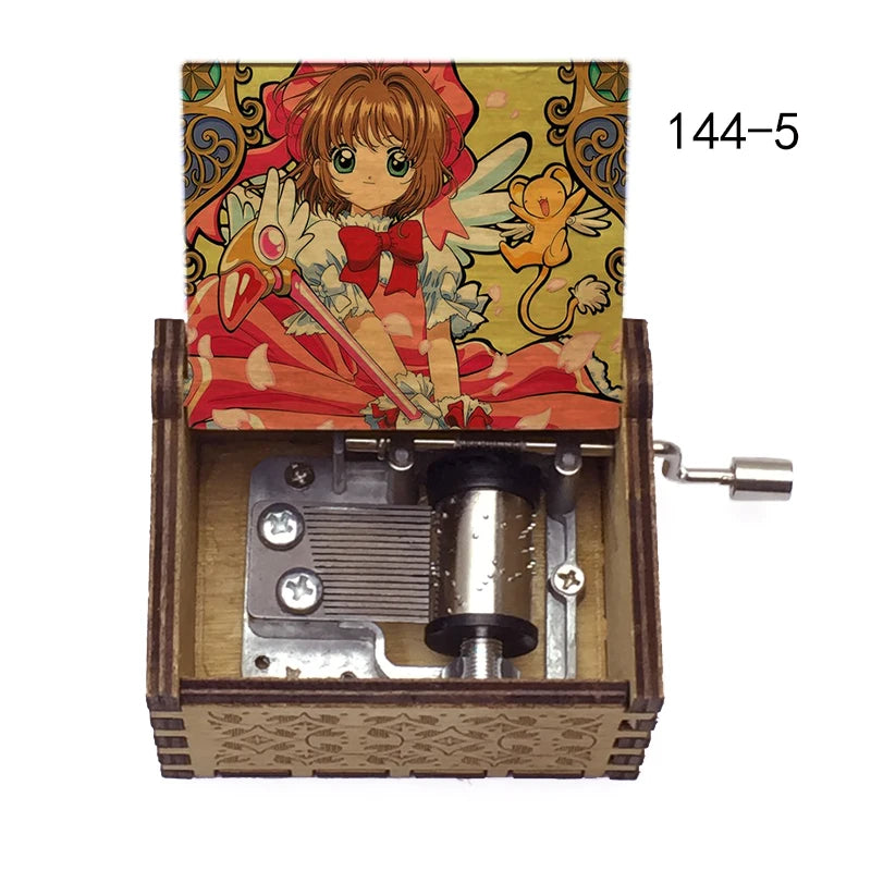 A music box featuring a Cardcaptor Sakura character, with an open wooden case and a hand crank mechanism.