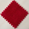 A square red plush interlocking floor tile with a textured surface.