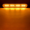 An illuminated amber strobe warning light bar mounted on a dark surface.