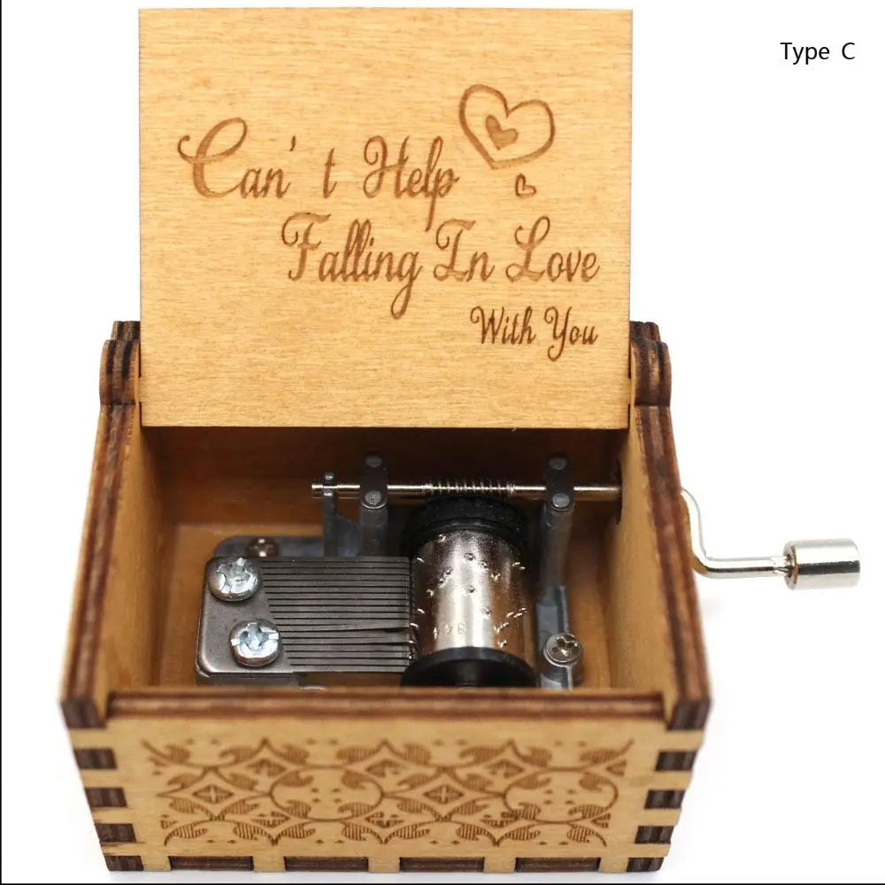A vintage hand-cranked wooden music box plays the song Can't Help Falling in Love, featuring a carved lid and wooden casing.