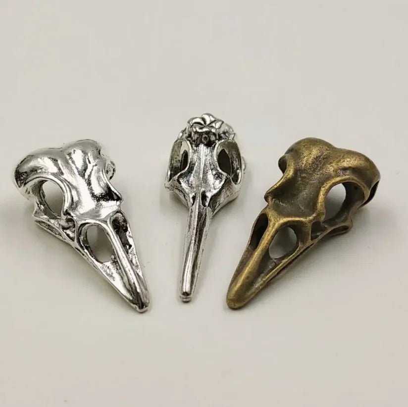 A set of five gothic skull and crow head charms for jewelry making, featuring silver and bronze finishes.