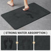 A dark gray non-slip mat designed for pet feeding, showing the bottom view of a foot and a paw print.
