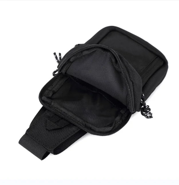 Black compact canvas crossbody bag shown open with a strap attached