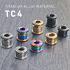 Several titanium alloy chainring bolts of different sizes and finishes are displayed on a dark surface.