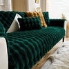 Dunkelgrüne Plüschkaninchen-Sofa-Kissen über weißes Sofa mit goldenem Akzentkissen und weißem Kunstfell