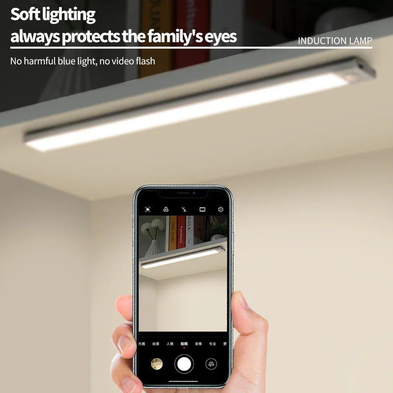 A hand holds a smartphone displaying an induction lamp light fixture installed in a ceiling.