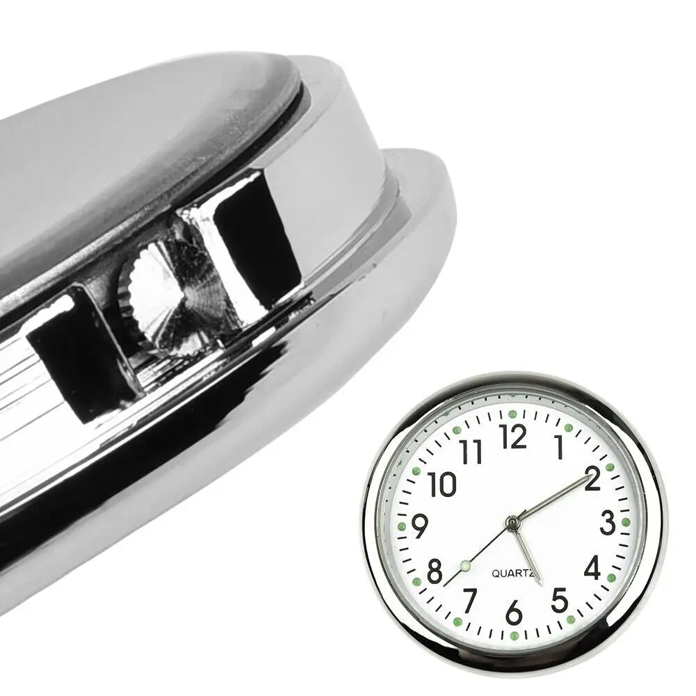 A close-up view of a silver mini car vent quartz clock with luminous hands.