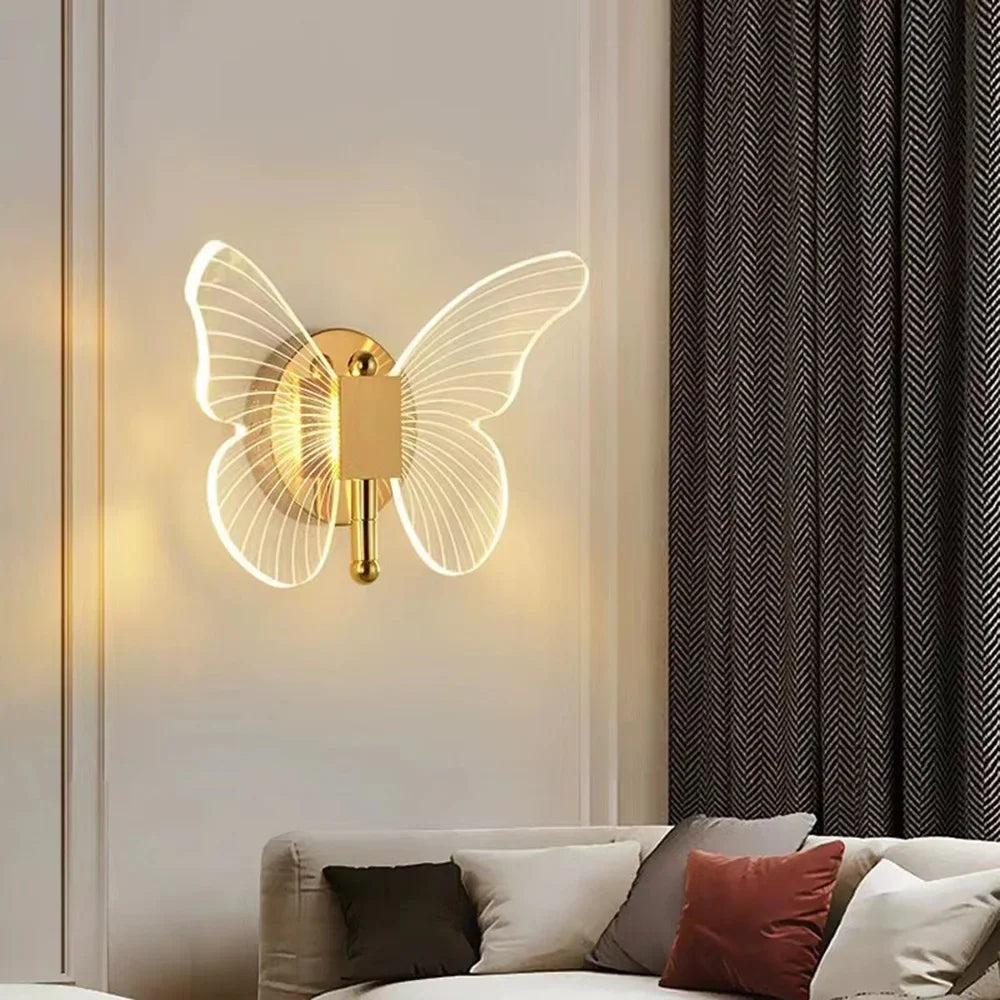 مصباح حائط من LED على شكل فراشة عصري بلمسة ذهبية مثبت على جدار أبيض.
