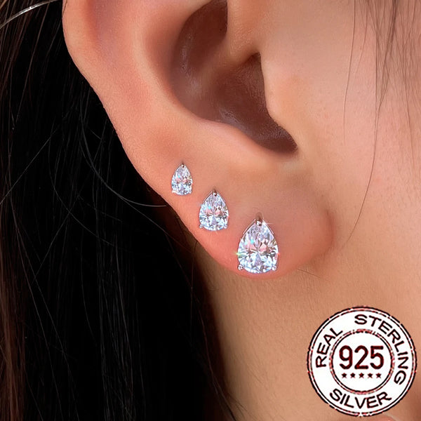 A close-up of sterling silver water drop cubic zirconia earrings displayed on a person's ear.