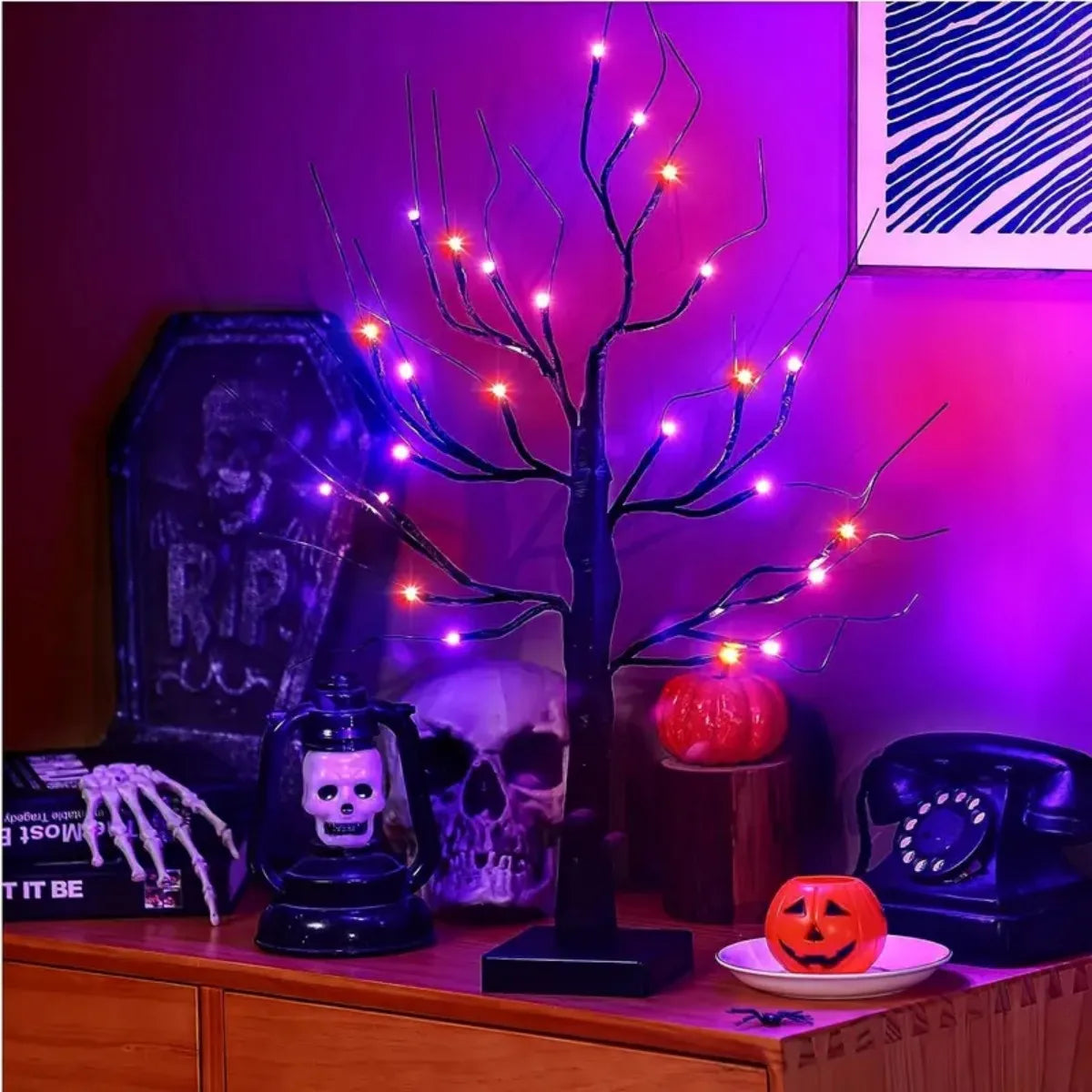 An LED Halloween birch tree with dark branches illuminated by orange and purple lights against a purple background.