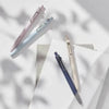 Three Uni ZENTO Quick-Dry Gel Pens in pink and blue shades are shown diagonally on a white background.