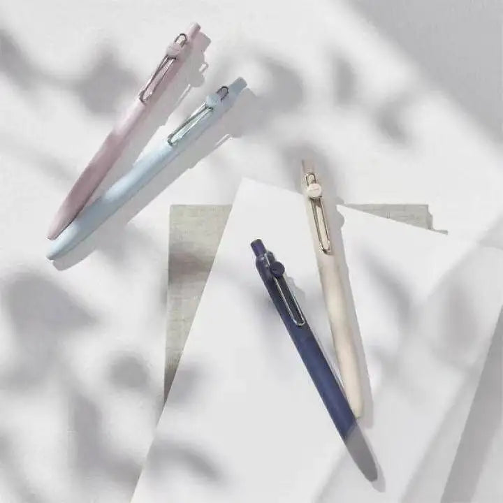 Three Uni ZENTO Quick-Dry Gel Pens in pink and blue shades are shown diagonally on a white background.