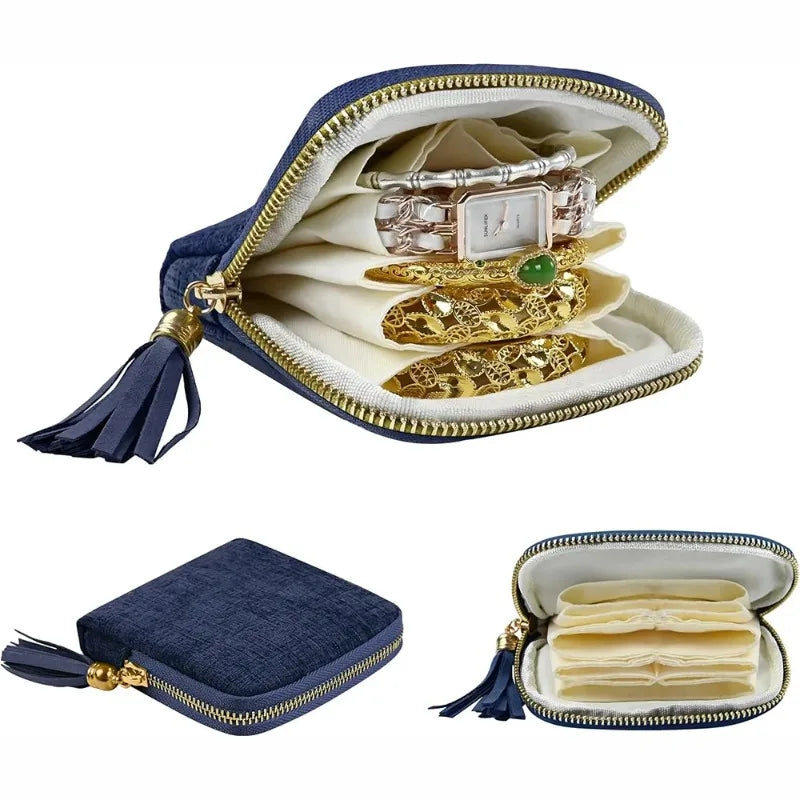A navy velvet jewelry organizer bag with a gold zipper and tassel, displaying stacked gold jewelry.