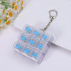 A clear plastic tactile clicking keyboard fidget toy with blue buttons attached to a silver keychain ring.