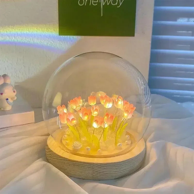 A handcrafted tulip LED night light with yellow flowers sits on a wooden base inside a clear glass dome.