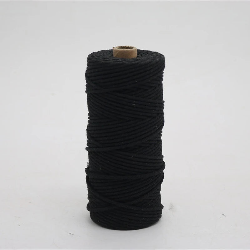 A spool of black macrame cord, 3mm/4mm thickness, used for crafting.